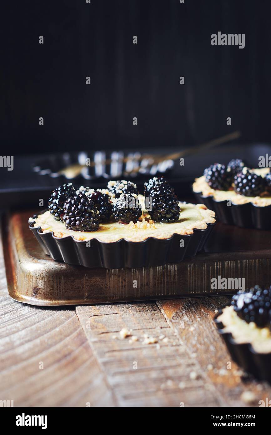 Frisch gebackene Brombeeren- und Vanillepudding-Torten. Stockfoto