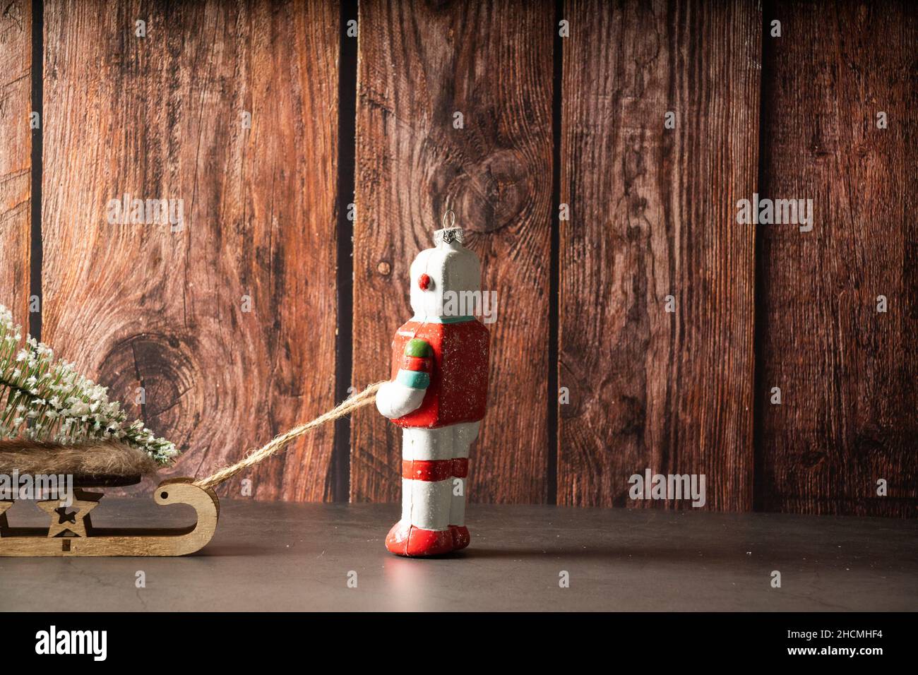 Weihnachtsroboter, der einen Schlitten von hinten zieht Stockfoto