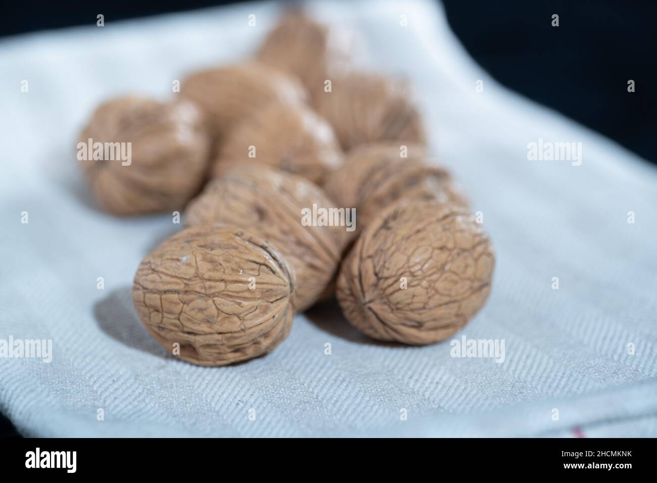 Helsinki / Finnland - 27. DEZEMBER 2021: Ein Haufen ganze Walnüsse auf einem Küchentuch. Stockfoto
