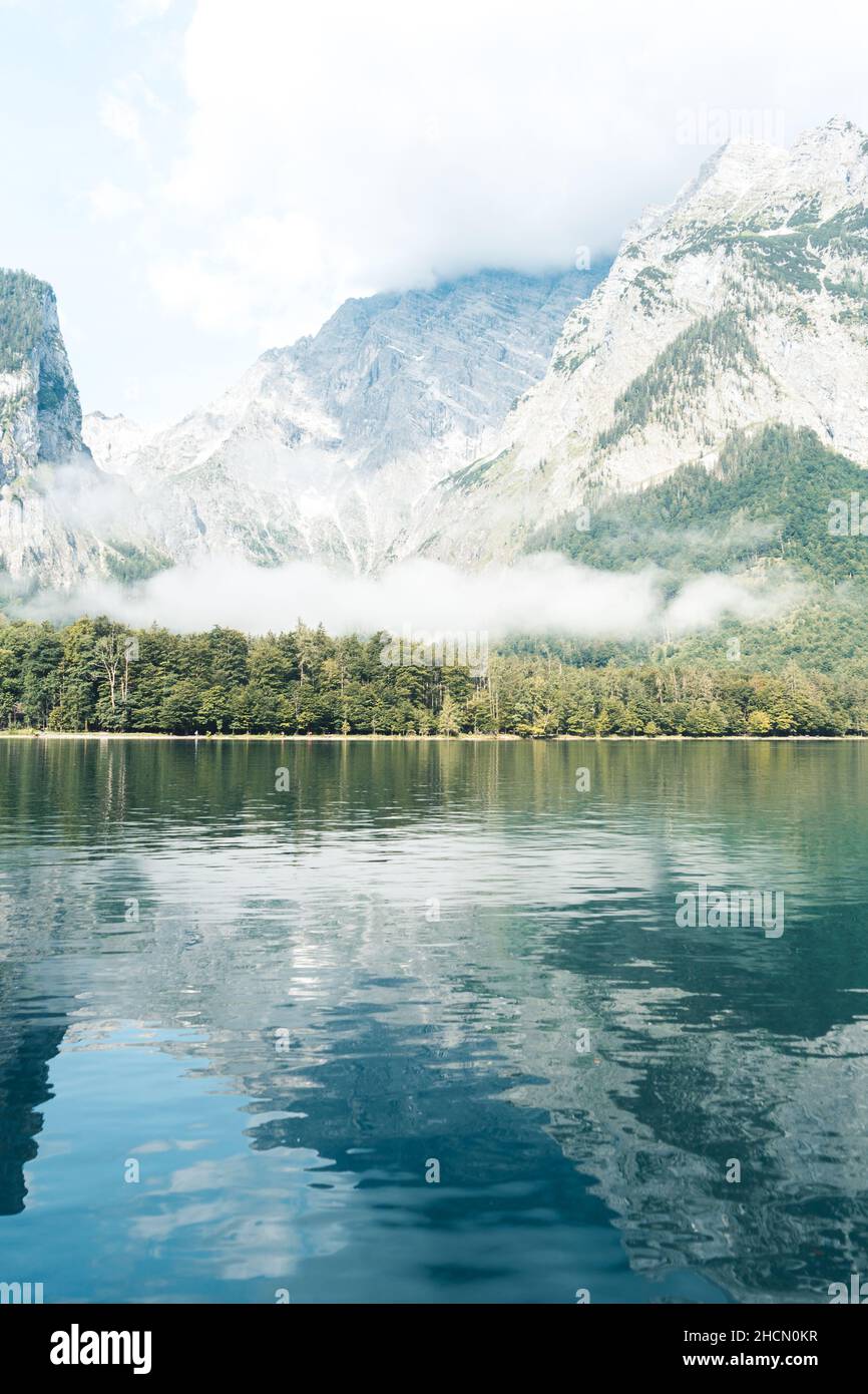 Spiegelnde Berge, Wald und Nebel im Wasser des Königssee im Berchtesgadener Land, Bayern, Deutschland Stockfoto