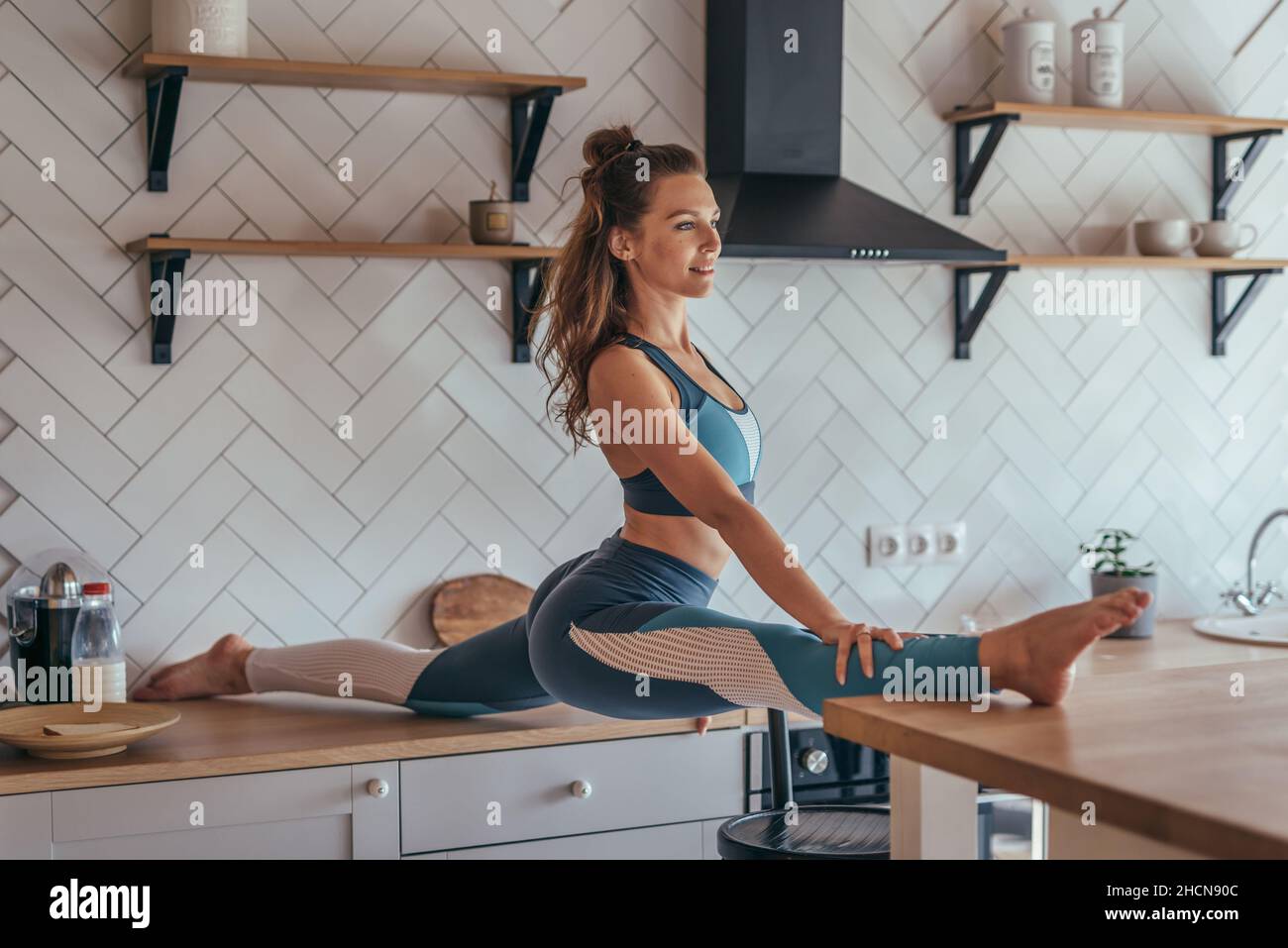 Mädchen tun vorne aufgeteilt zwischen zwei Tischen in der Küche Stockfoto