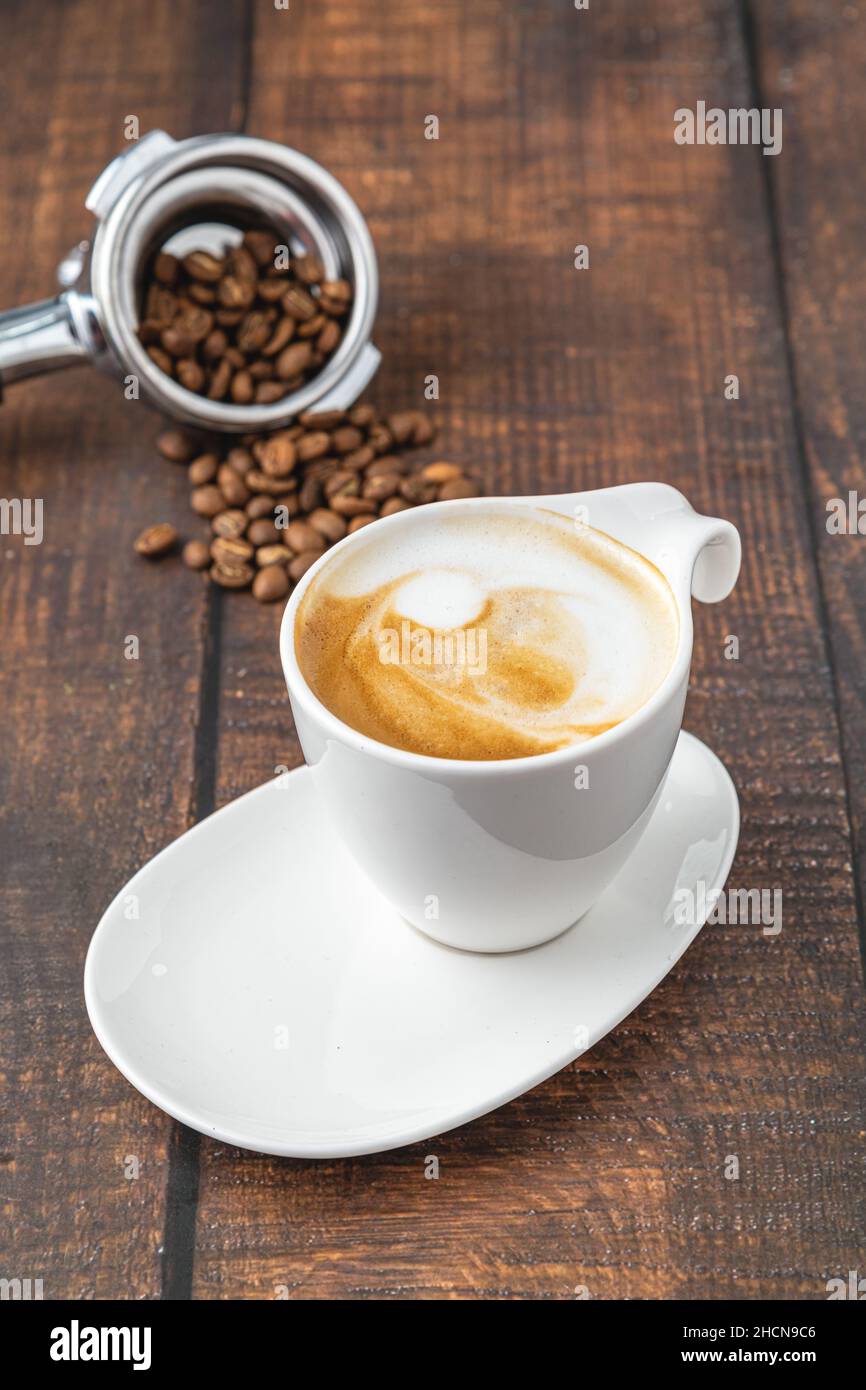 Entspannender Latte-Kaffee in weißer Porzellanschale auf Holztisch Stockfoto