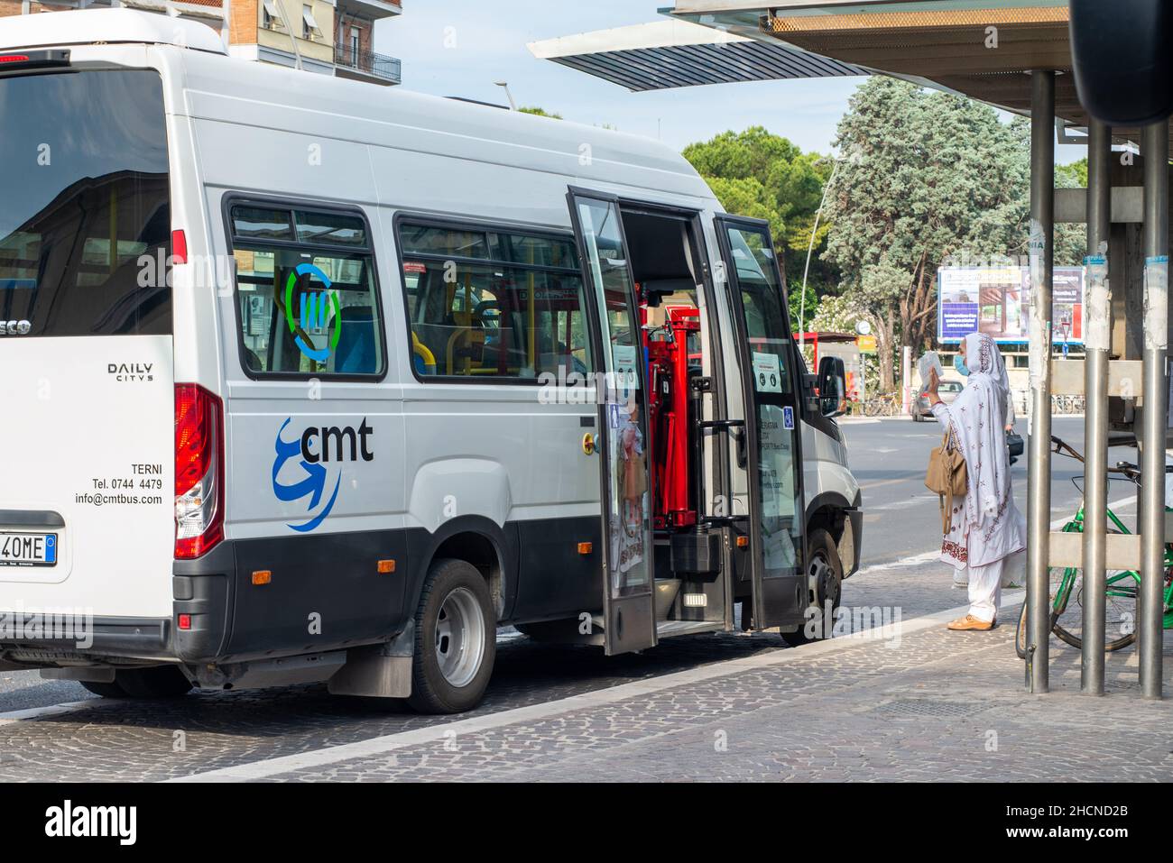 terni, italien Mai 29 2020:Bus einer lokalen Genossenschaft und ausländische Frau, die um Informationen mit Maske für covid Notfall bittet Stockfoto