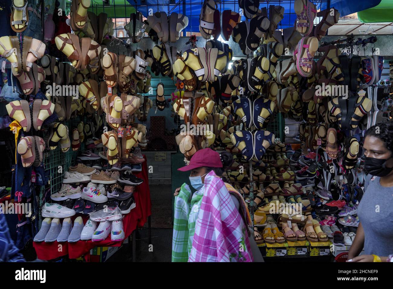 San Salvador, El Salvador. 30th Dez 2021. Frauen sahen, wie sie an einem Schuhgeschäft am Straßenmarkt vorbeigingen, während die Leute am Silvesterabend in der Innenstadt einkaufen. Kredit: SOPA Images Limited/Alamy Live Nachrichten Stockfoto