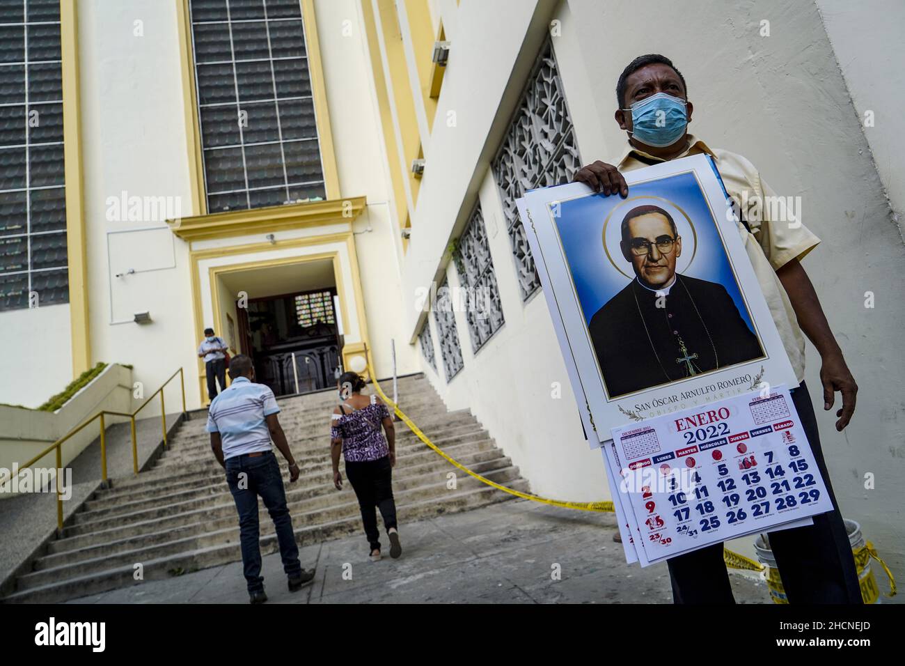 San Salvador, El Salvador. 30th Dez 2021. Ein Mann verkauft 2022 Kalender außerhalb der Kathedrale von San Salvador, während die Leute in der Innenstadt für den Silvesterabend einkaufen. (Foto von Camilo Freedman/SOPA Images/Sipa USA) Quelle: SIPA USA/Alamy Live News Stockfoto