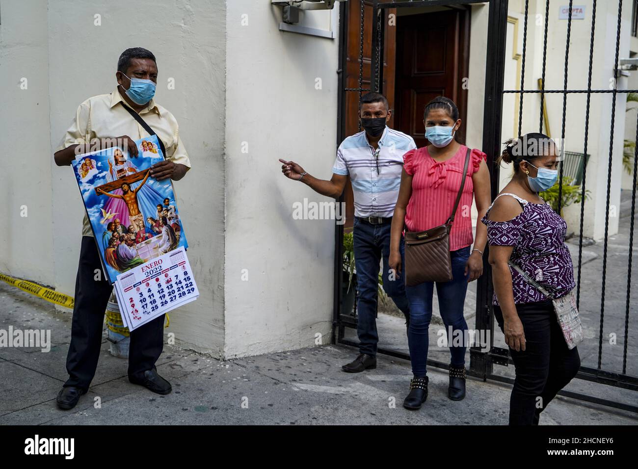 San Salvador, El Salvador. 30th Dez 2021. Ein Mann verkauft 2022 Kalender außerhalb der Kathedrale von San Salvador, während die Leute in der Innenstadt für den Silvesterabend einkaufen. (Foto von Camilo Freedman/SOPA Images/Sipa USA) Quelle: SIPA USA/Alamy Live News Stockfoto