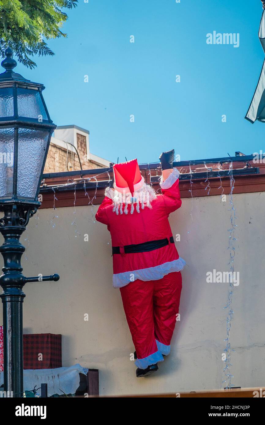 Ein aufblaster weihnachtsmann, der eine Wand eines Geschäftsgebäudes klettert. Stockfoto