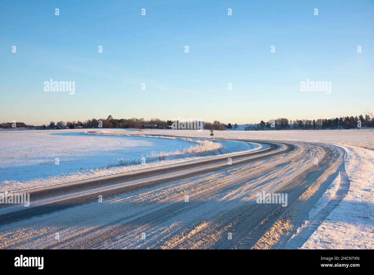 Kurvige Winterstraße mit Schnee und Eis Stockfoto