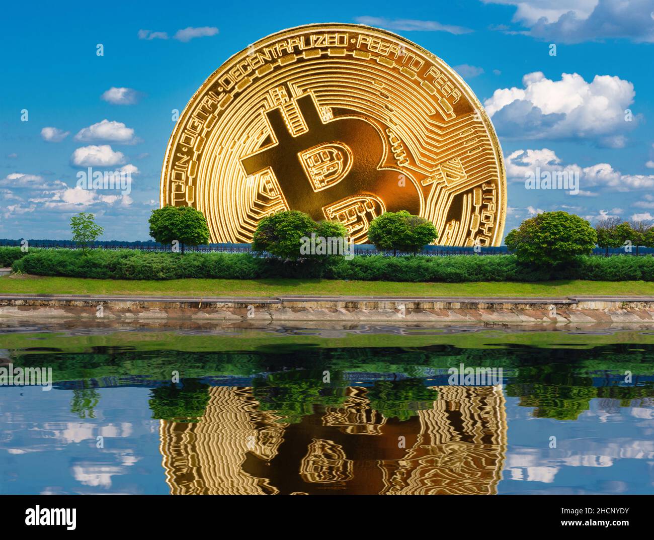 Bitcoin-Münze über grünen Bäumen und deren Spiegelung im Wasser in einer Fotocollage. Stockfoto