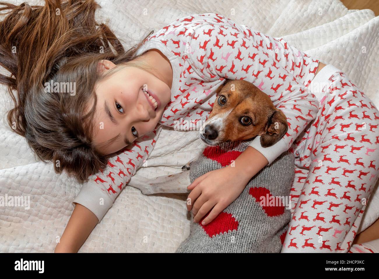 Ein 9-jähriges Mädchen mit ihrem Haustier auf ihrem Bett Stockfoto