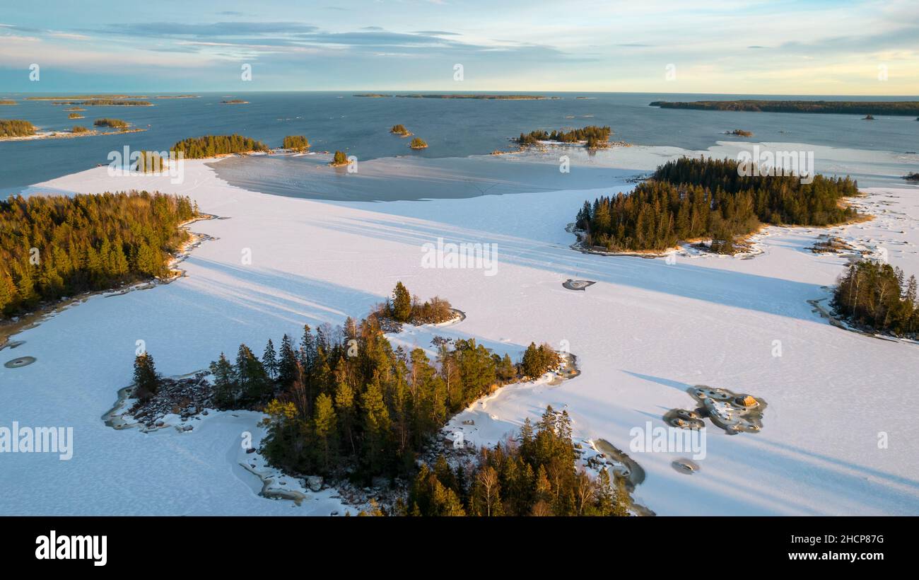 Luftaufnahme eines kleinen schwedischen Dorfes mit Inseln und Wäldern an der Ostseeküste im Winter. Drohnenfotografie - Winter in Gavleborg County, A Stockfoto