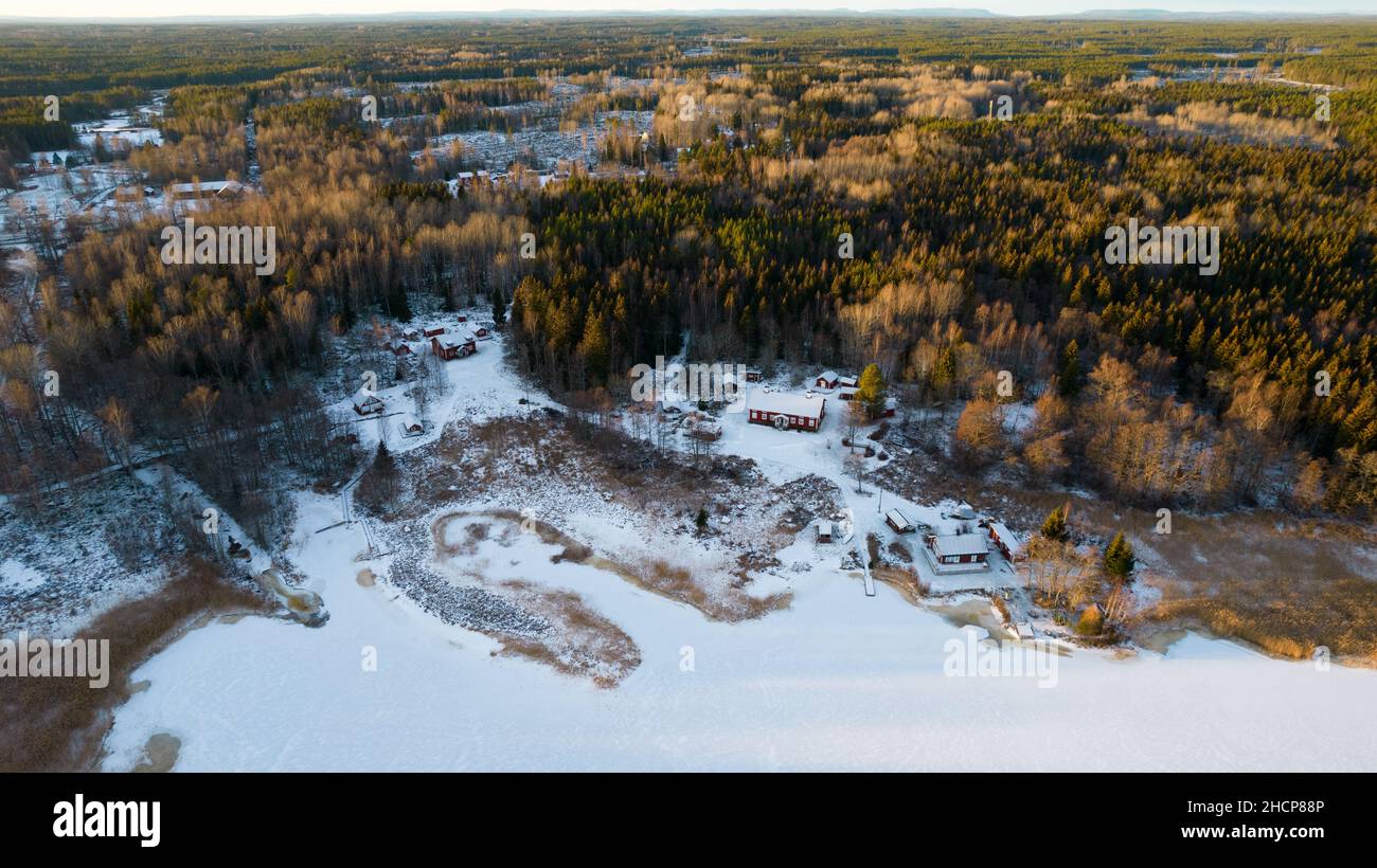 Luftaufnahme eines kleinen schwedischen Dorfes mit Inseln und Wäldern an der Ostseeküste im Winter. Drohnenfotografie - Winter in Gavleborg County, A Stockfoto
