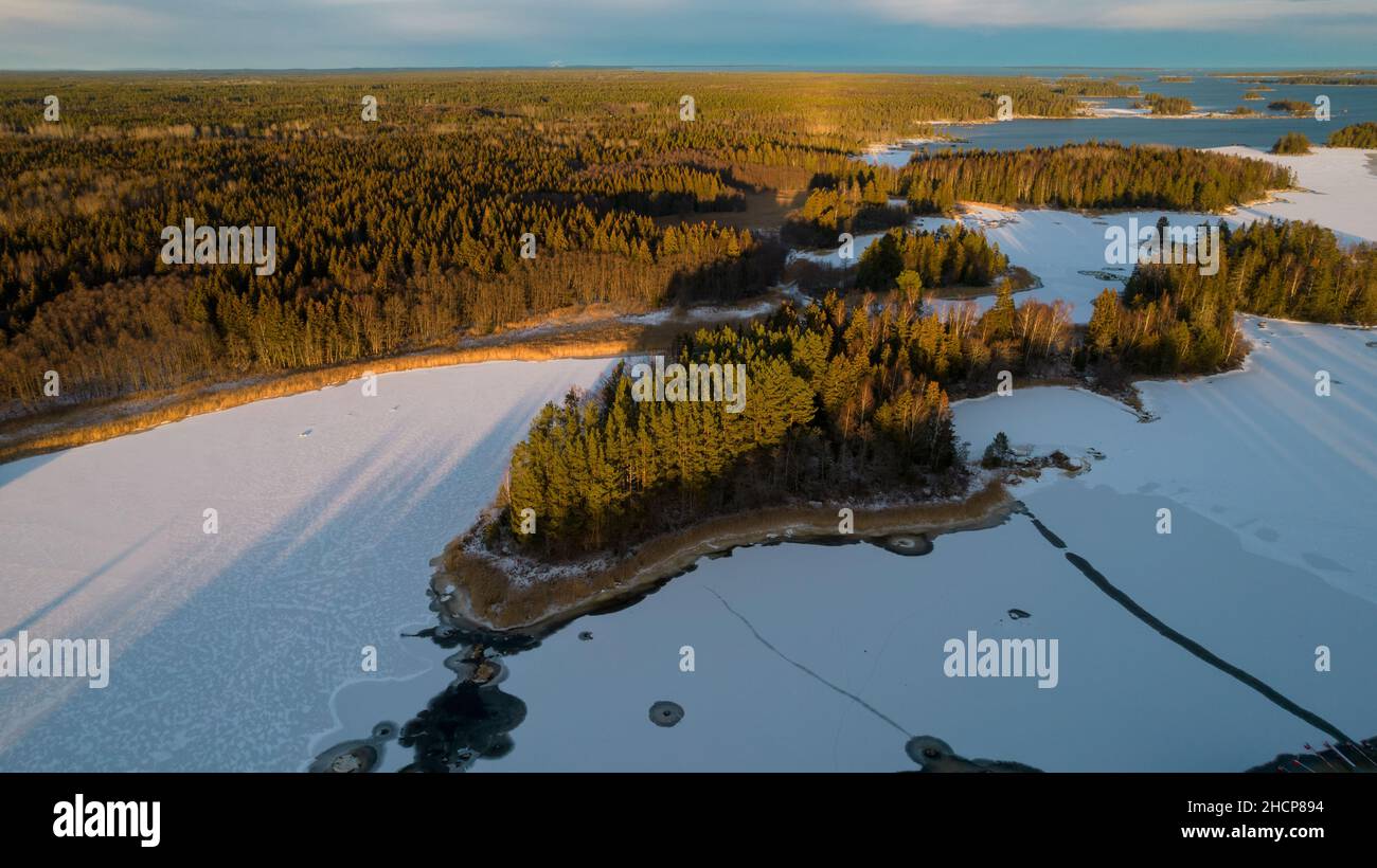 Luftaufnahme eines kleinen schwedischen Dorfes mit Inseln und Wäldern an der Ostseeküste im Winter. Drohnenfotografie - Winter in Gavleborg County, A Stockfoto