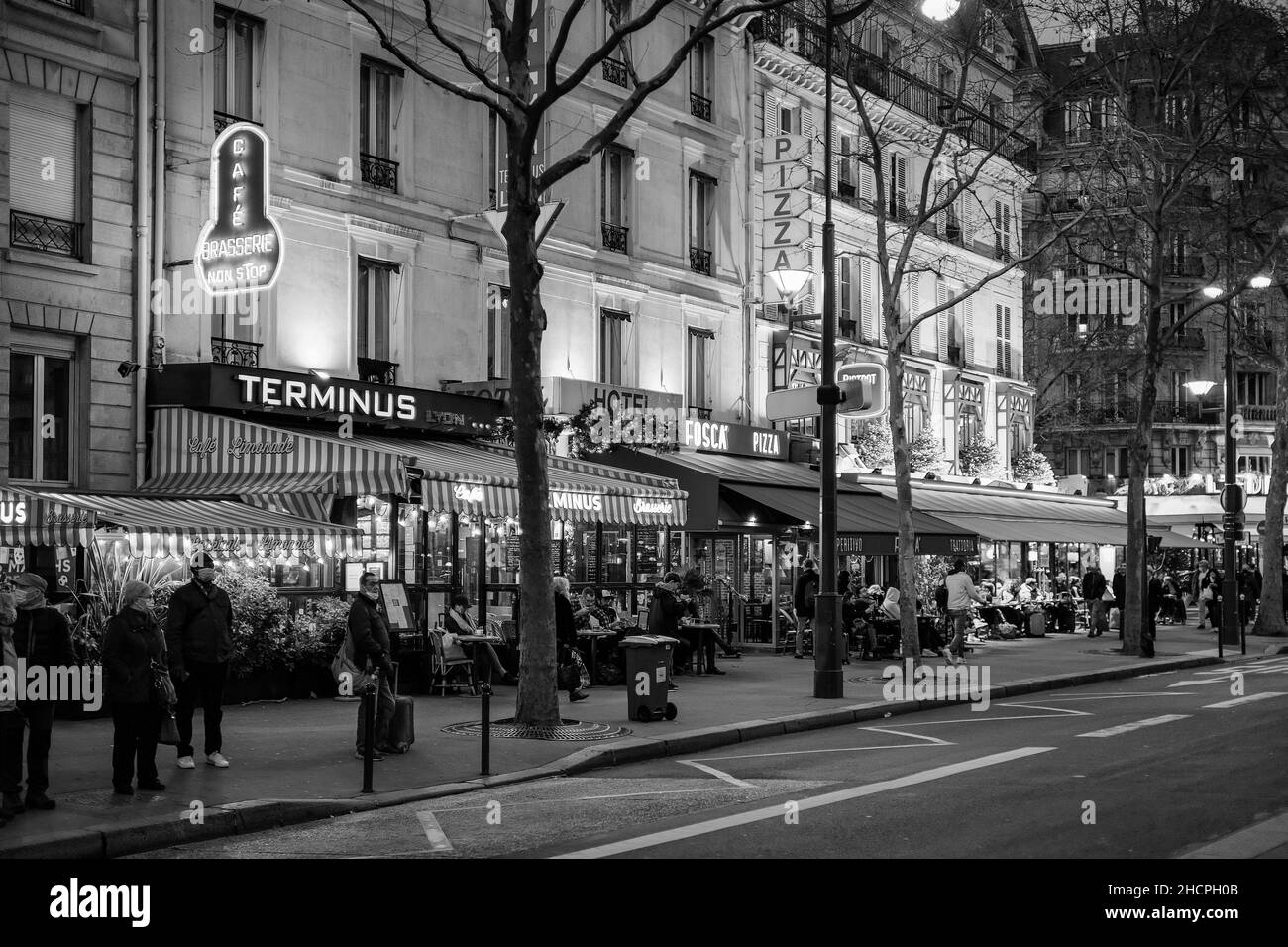 Paris, Frankreich - 30. Dezember 2021 : Blick auf eine typische geschäftige Pariser Straße mit Restaurants und Bars in der Nacht Stockfoto