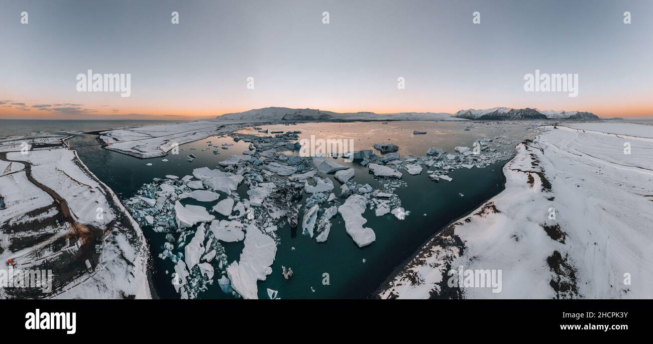 Luftdrohnenpanorama des berühmten Joekulsarlon-Sees und des Diamantenstrandes mit seinen Eisbergen und Eisschollen in Island während der Dämmerung bei Sonnenuntergang Stockfoto