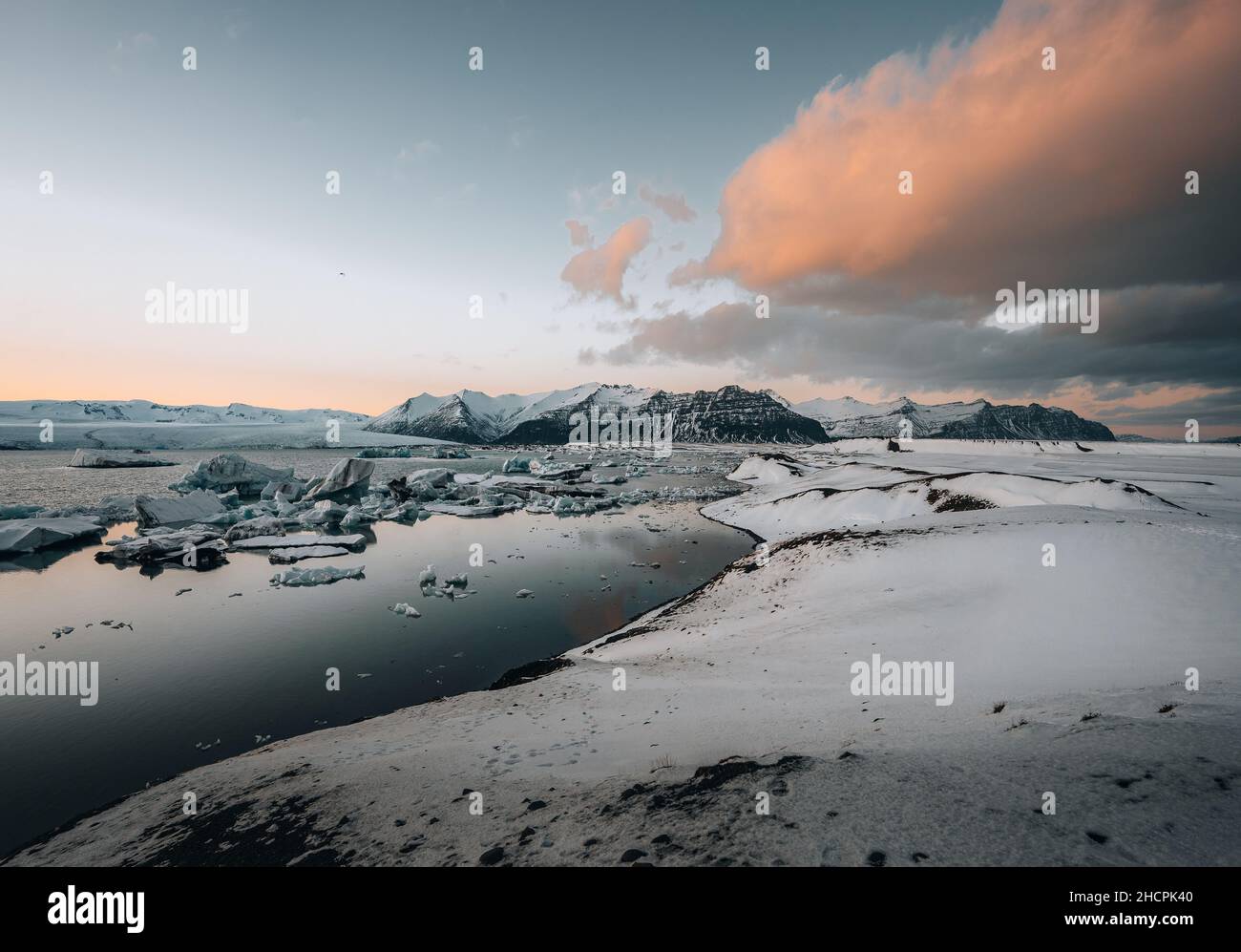 Luftdrohnenpanorama des berühmten Joekulsarlon-Sees und des Diamantenstrandes mit seinen Eisbergen und Eisschollen in Island während der Dämmerung bei Sonnenuntergang Stockfoto