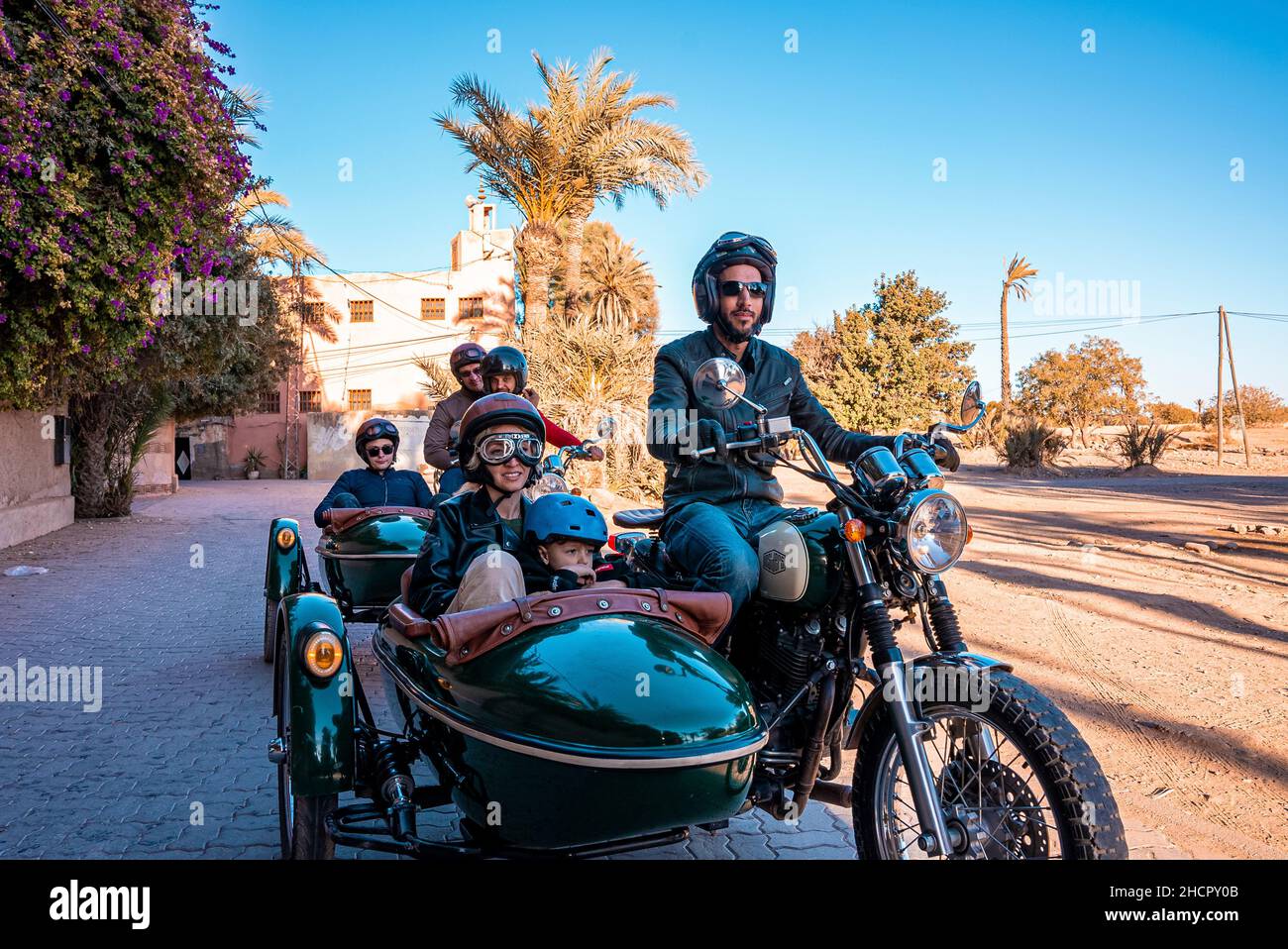 Gruppe von Leuten, die auf einem Oldtimer-Motorrad mit Seitenwagen unterwegs sind Stockfoto