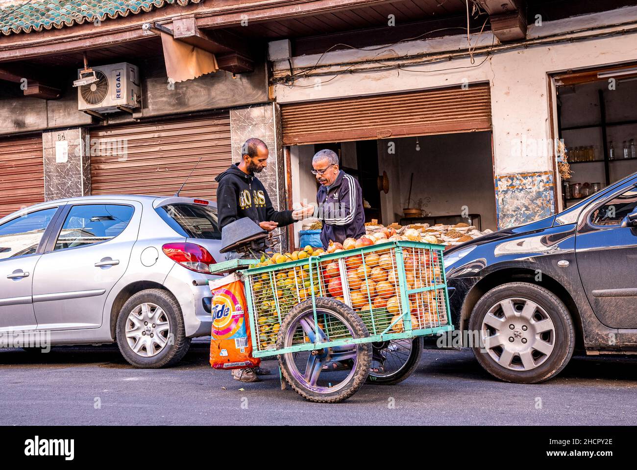 Ein alter männlicher Kunde kauft Obst vom Obsthändler mit Wagen auf der Straße Stockfoto