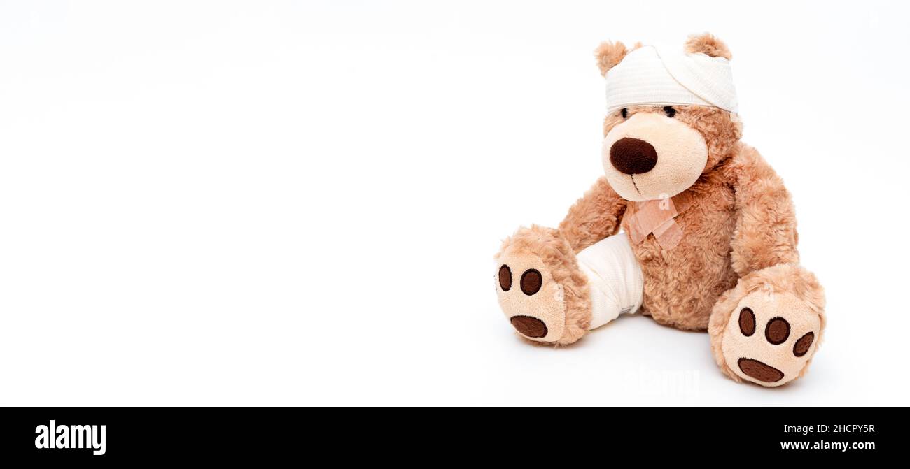 Teddybär mit Bandage, kindermedizinisches Betreuungskonzept. Bär auf weißem Hintergrund Stockfoto