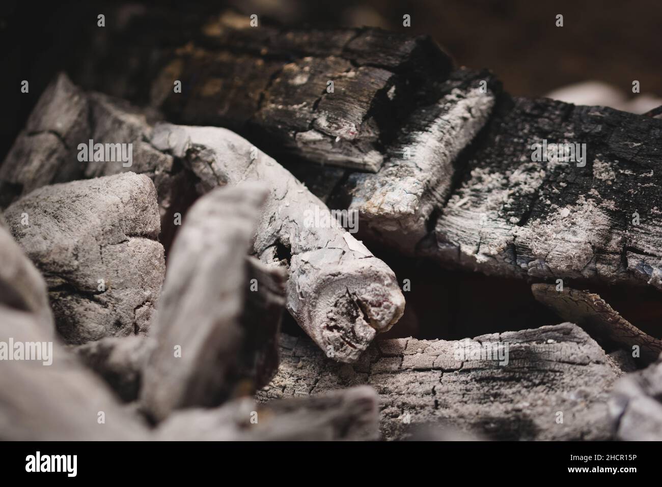 Schwelende Glut und Asche in einem Lagerfeuer. Nahaufnahme. Stockfoto