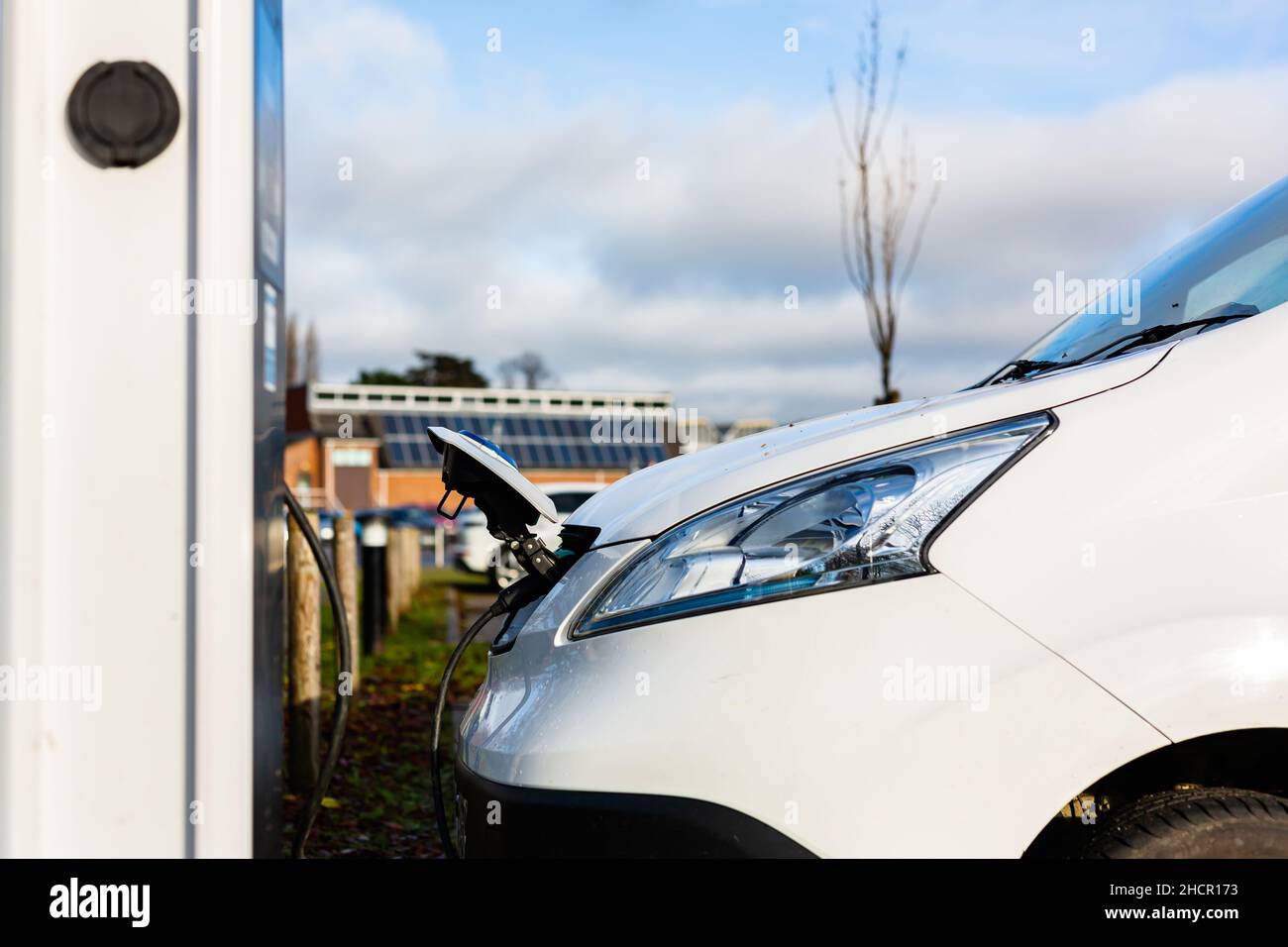 Laden von Elektroautos an der Plug-in-Ladestation in einem öffentlichen Parkplatz in Suffolk, Großbritannien Stockfoto