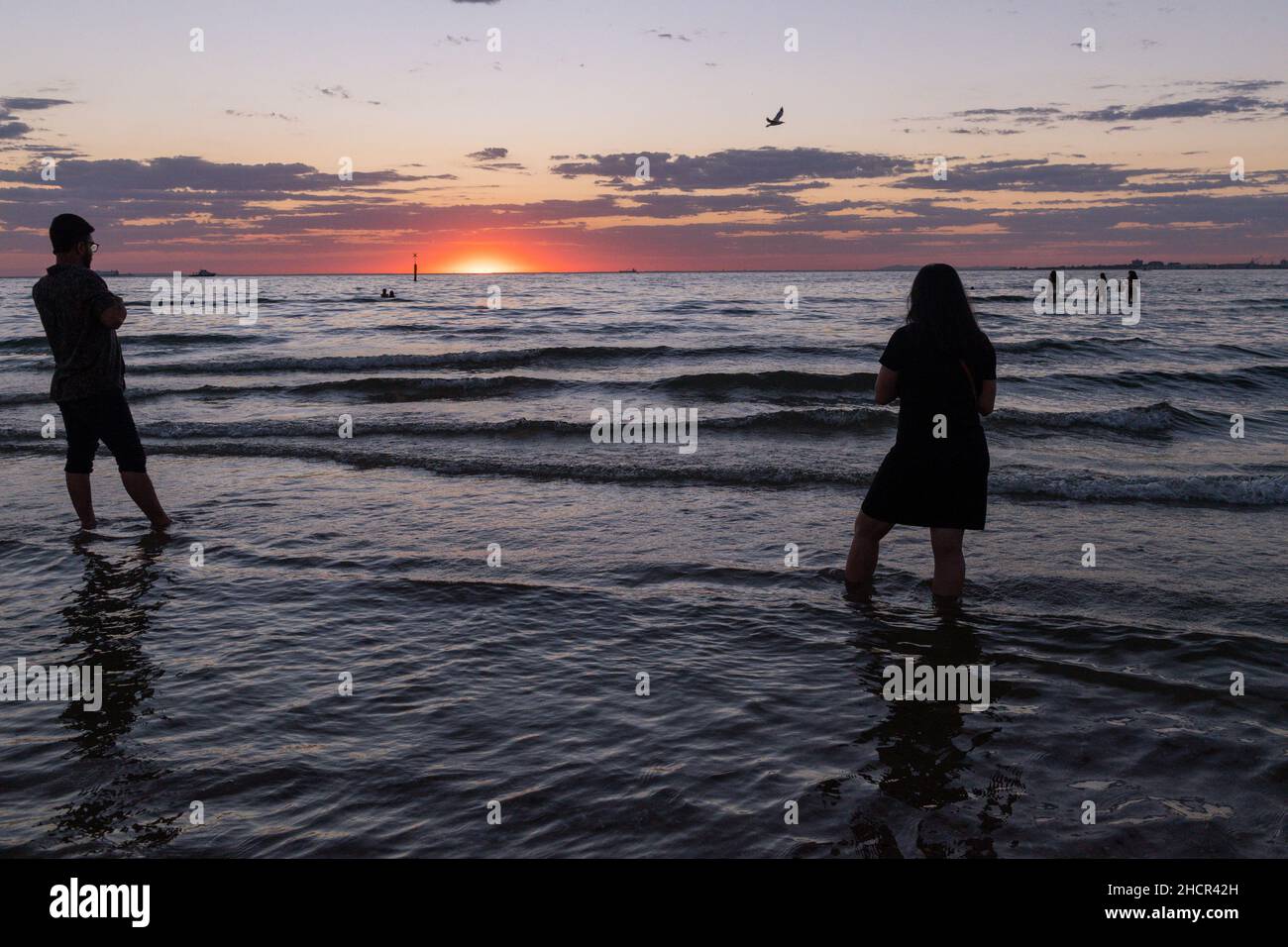 Melbourne, Australien 31 Dec 2021, die Menschen beobachten den Sonnenuntergang am letzten Tag des 2021 am St Kilda Beach an einer Nacht, die Ereignisse in Melbourne sah, bei denen die Menschen im neuen Jahr feierten und tranken mit Freunden und Feuerwerk, mit der Hoffnung auf ein besseres 2022! Kredit: Michael Currie/Alamy Live Nachrichten Stockfoto