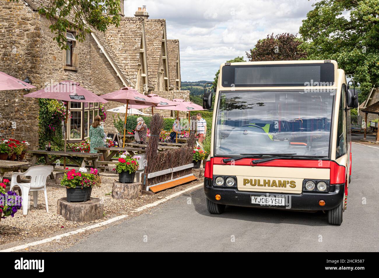Ein Pulhams-Reisebus fährt am öffentlichen Haus von „Crepenters Arms“ im Cotswold-Dorf Miserden, Gloucestershire, Großbritannien, vorbei Stockfoto