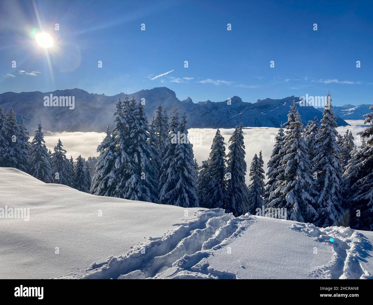 Sonnenschein in einer verschneiten Berglandschaft in der Schweiz Stockfoto