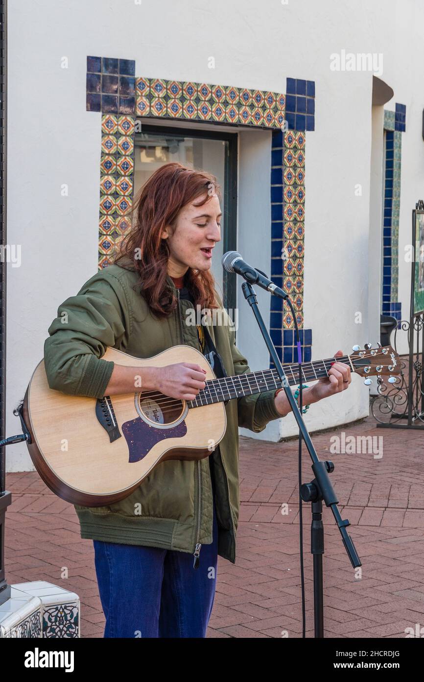 Eine Volksmusikerin spielt draußen Gitarre Stockfoto