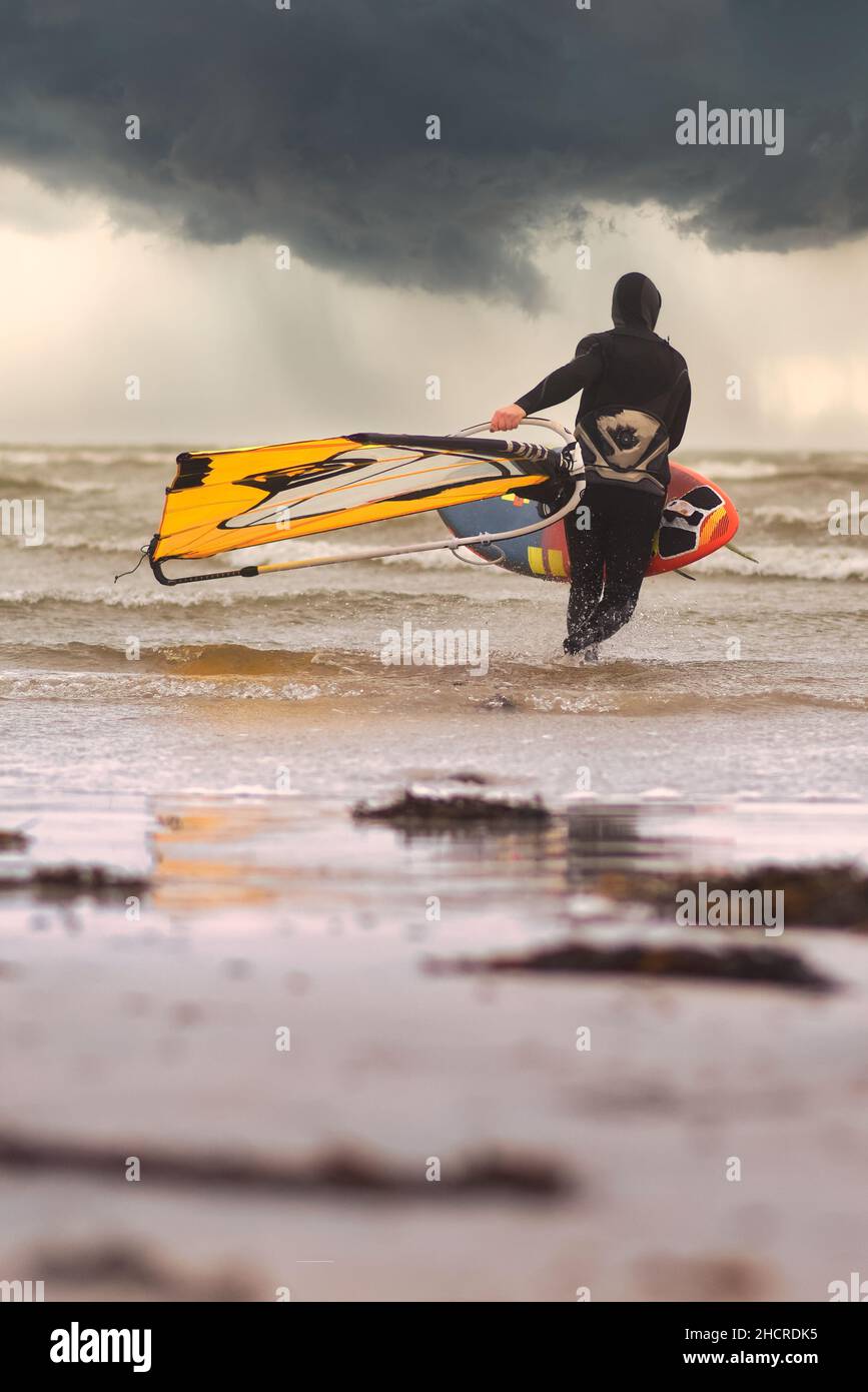 Surfer unter dramatisch bewölktem Himmel am Silver Strand in Galway, Irland Stockfoto