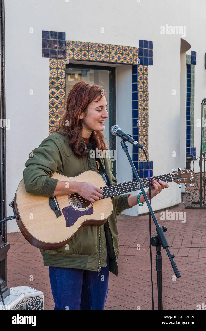 Eine Volksmusikerin spielt draußen Gitarre Stockfoto