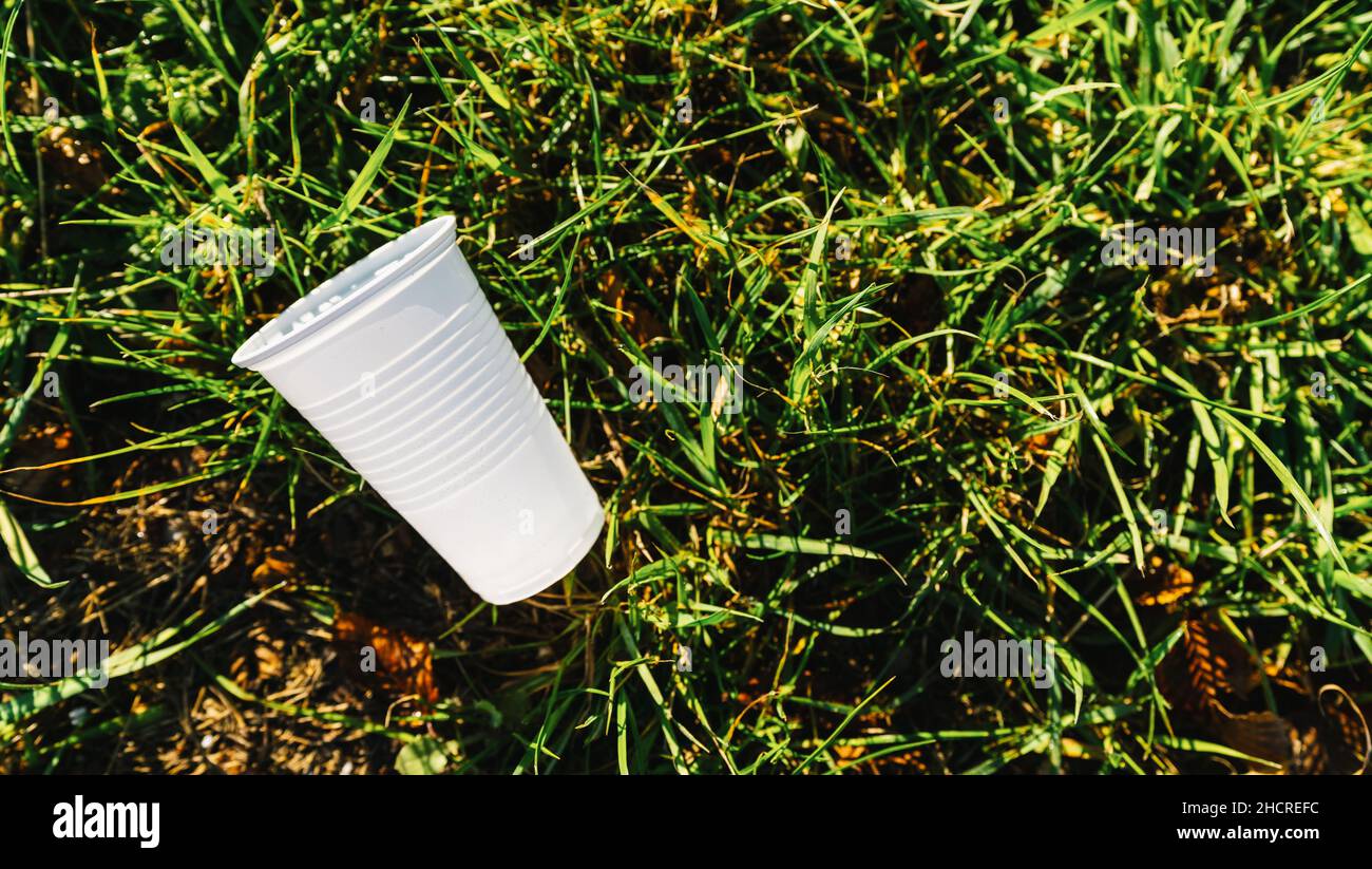 Weiße Plastikbecher Verschmutzung auf einer Wiese. Copyspace für Ihren individuellen Text Stockfoto
