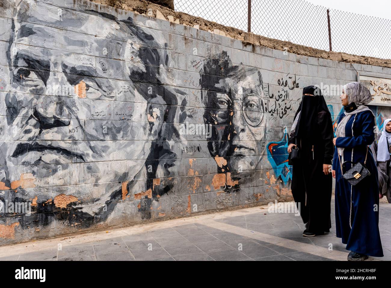 Eine Gruppe von Frauen geht an Einem Wandbild in der Innenstadt von Amman, Amman, Jordanien, vorbei. Stockfoto