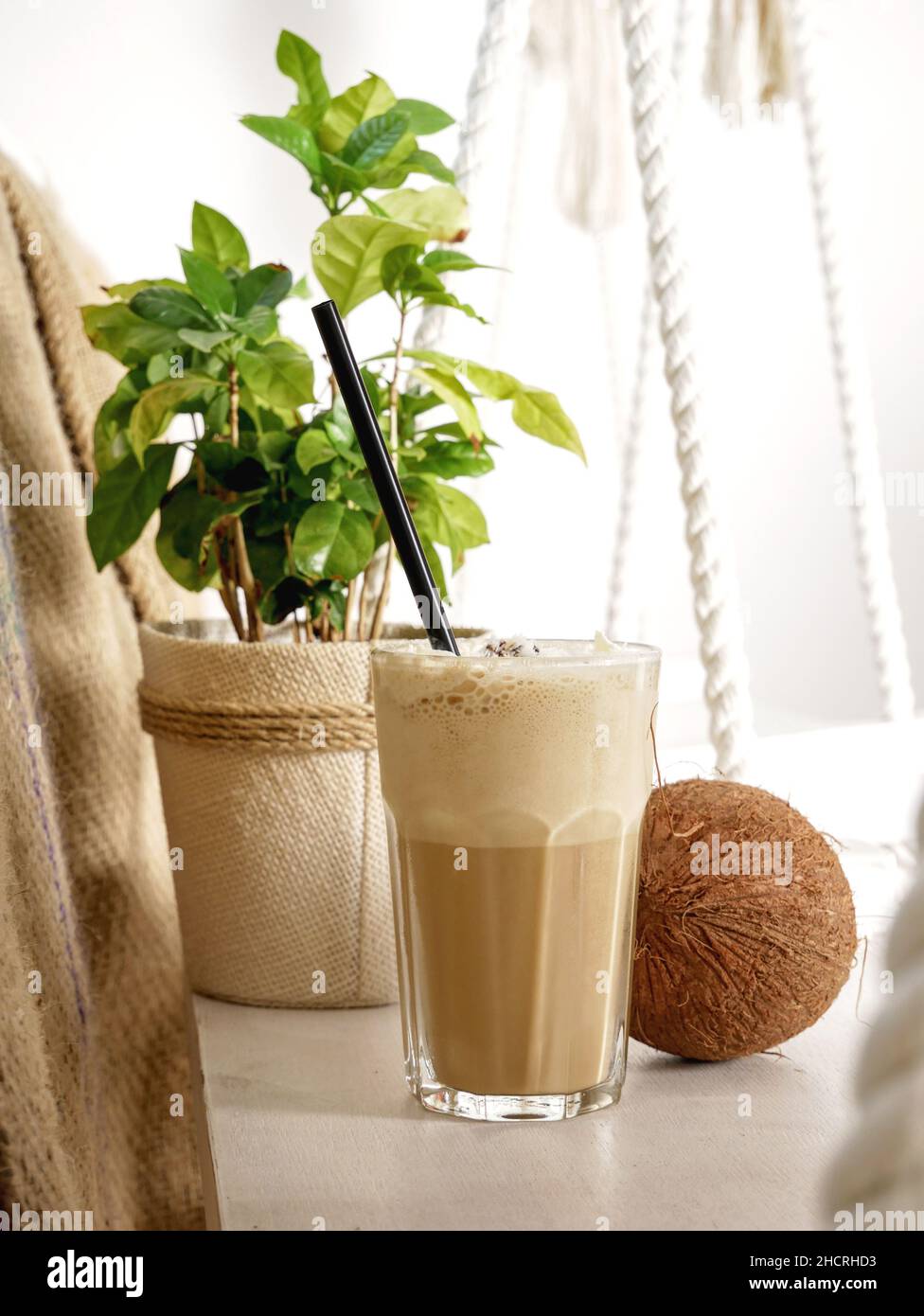 Coconut Latte in einem hohen Glas und Coconut auf einer Schaukel in einem Café. Nahaufnahme. Stockfoto