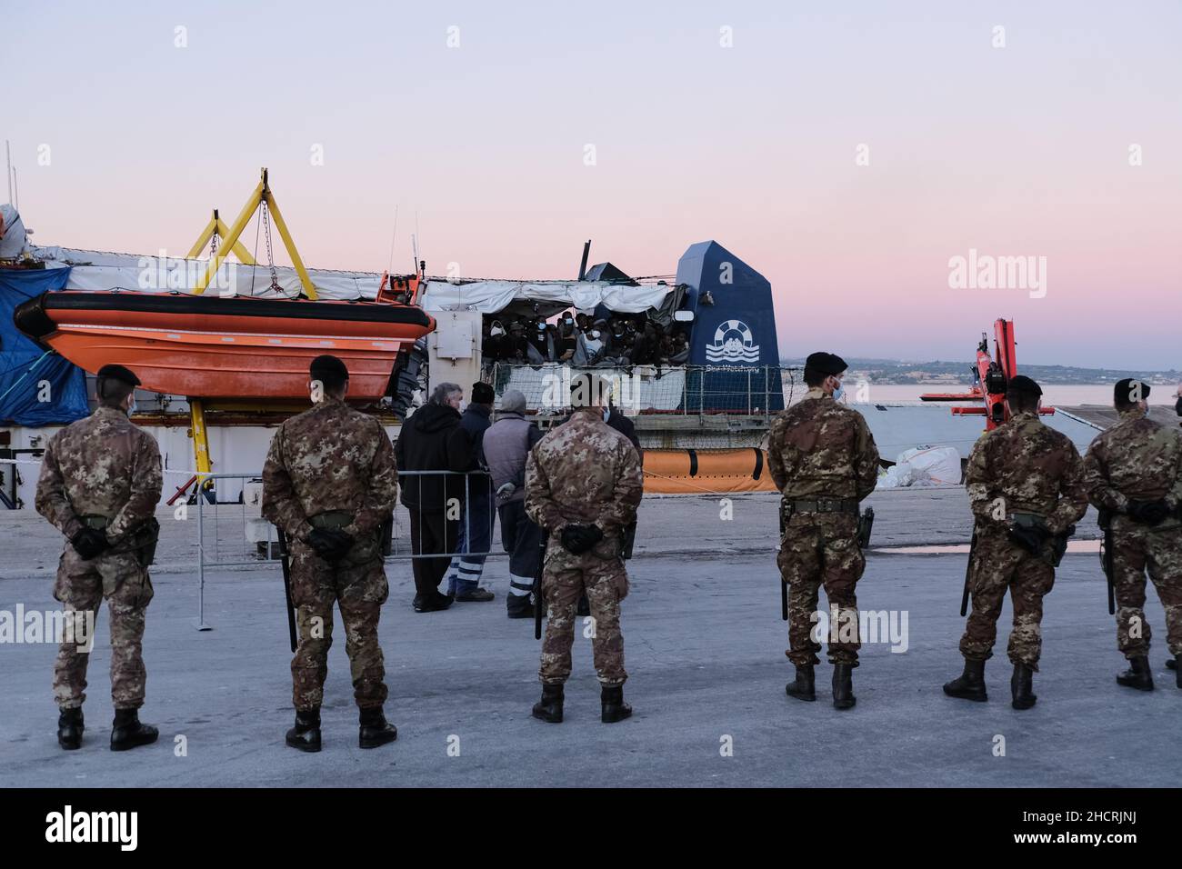 Sizilien, Italien. 31st Dez 2021. Die letzten Migranten kommen am letzten Tag des Jahres nach Sizilien. Die Seeretter der „Sea-Watch 3“ mit 440 Personen an Bord mussten 8 Tage warten, bis sie einen sicheren Hafen zugewiesen bekommen. Jetzt dürfen sie in die sizilianische Stadt Pozzallo einreisen.an Bord waren mehr als 200 Kinder, 167 davon ohne Eltern oder Begleiter. Sie alle gingen in kleinen Booten in Libyen auf See. Viele von ihnen kommen aus Ländern südlich der Sahara. Quelle: Alessio Tricani/Alamy Live News Stockfoto