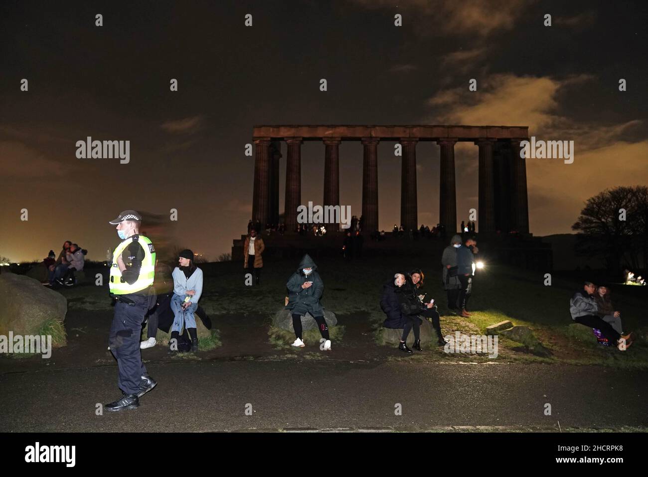 Während der Silvesternacht in Edinburgh versammelten sich Menschen auf dem Calton Hill, da die Begrenzung der Anzahl der Personen, die an Veranstaltungen teilnehmen können, dazu geführt hat, dass Silvesterpartys abgesagt wurden, einschließlich der für Edinburgh geplanten. Bilddatum: Freitag, 31. Dezember 2021. Stockfoto