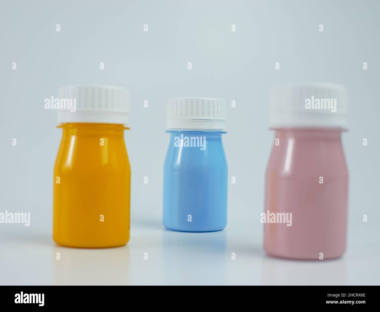 Pigmentharzfarbe in der Flasche, viele Farben haben Rosa, Blau und Orange. Isoliert auf weißem Hintergrund. Stockfoto