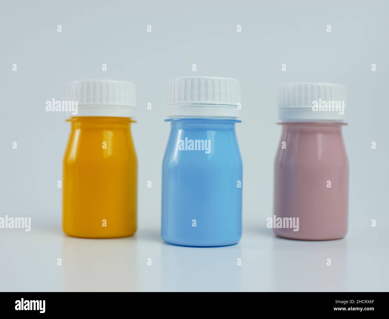 Pigmentharzfarbe in der Flasche, viele Farben haben Rosa, Blau und Orange. Isoliert auf weißem Hintergrund. Stockfoto