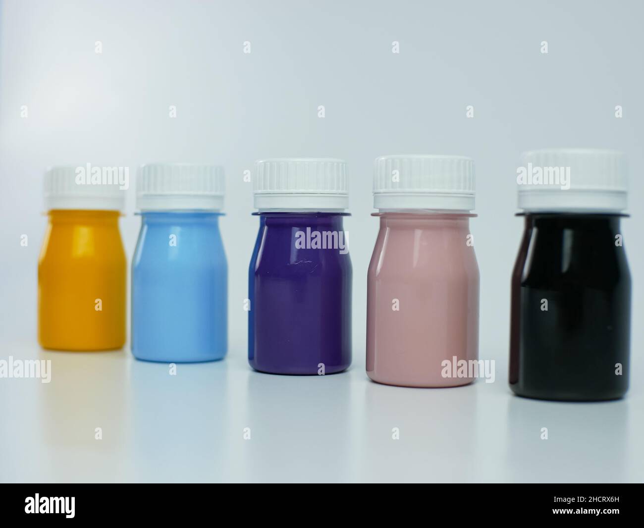 Pigmentharzfarbe in der Flasche, viele Farben gibt es lila, rosa, blau, orange und schwarz. Isoliert auf einem weißen Hintergrund. Stockfoto