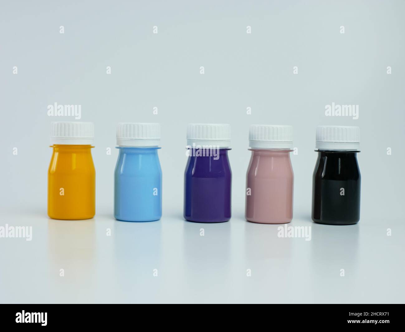 Pigmentharzfarbe in der Flasche, viele Farben gibt es lila, rosa, blau, orange und schwarz. Isoliert auf einem weißen Hintergrund. Stockfoto