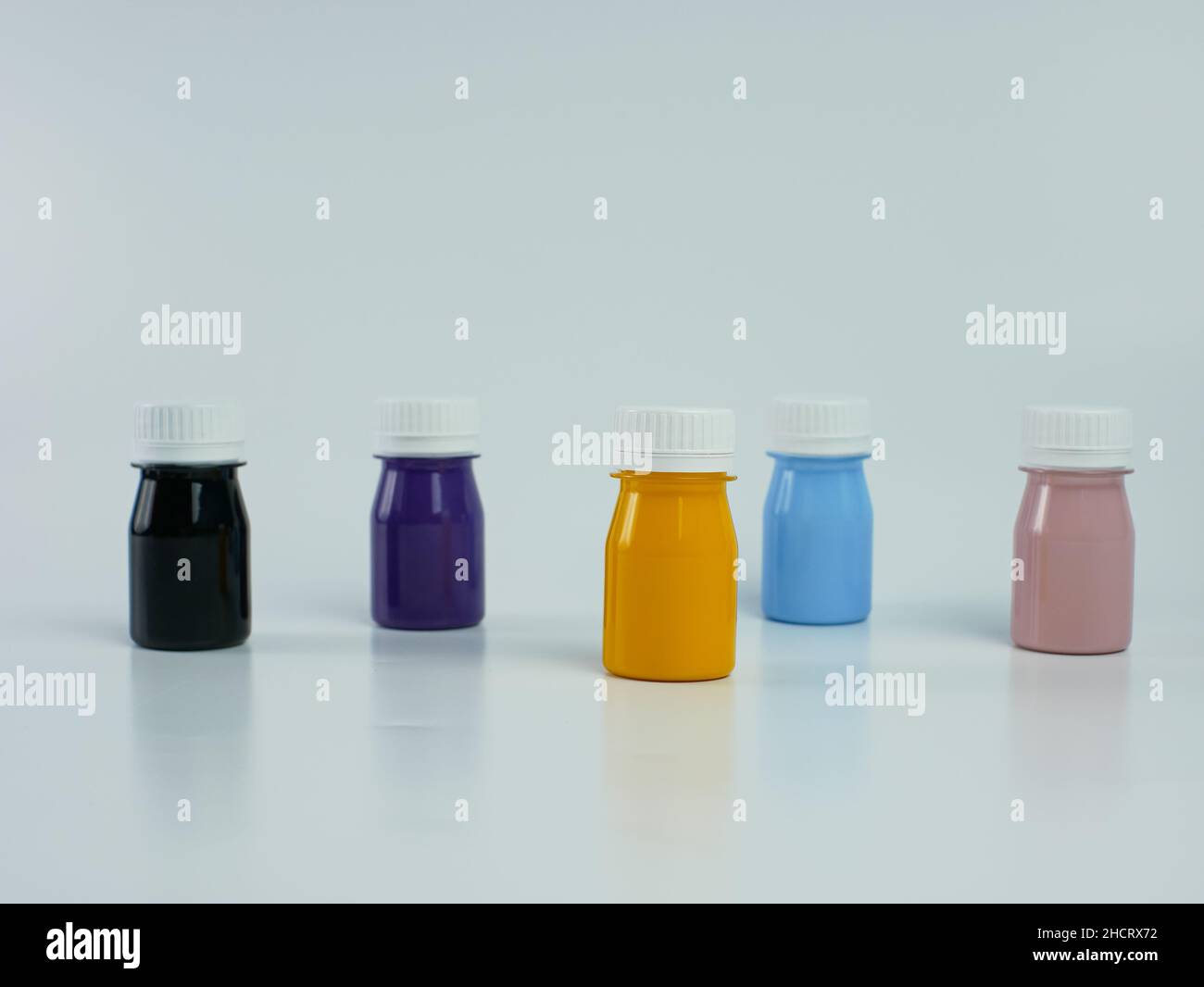 Pigmentharzfarbe in der Flasche, viele Farben gibt es lila, rosa, blau, orange und schwarz. Isoliert auf einem weißen Hintergrund. Stockfoto