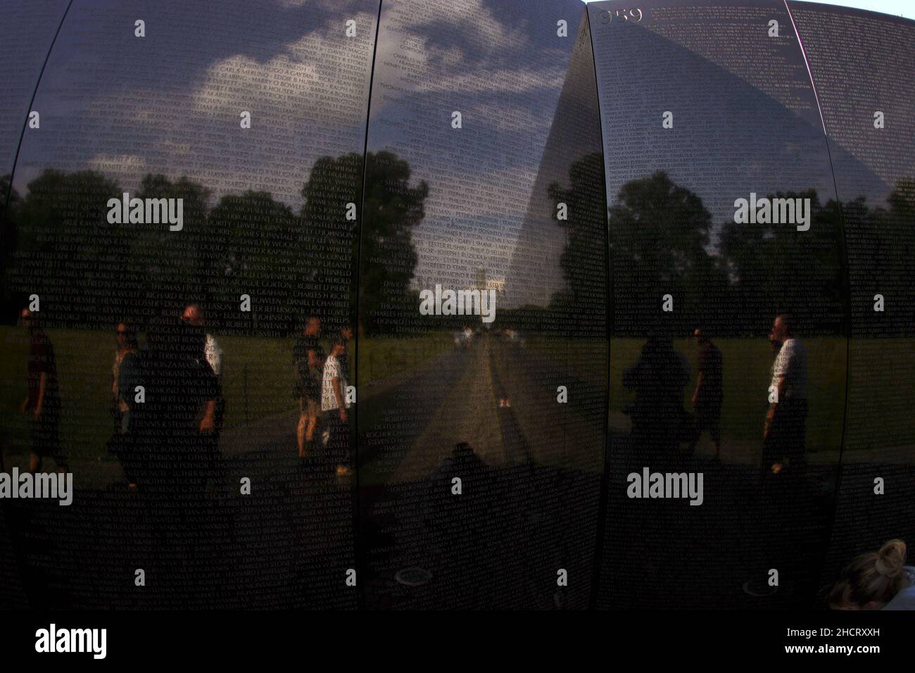 Das Vietnam Veterans Memorial in Washington, D.C. Auf der polierten Steinoberfläche der Gedenkstätten spiegeln sich die Besucher der Stätte und das Washington Monument in der Ferne. Das Denkmal wurde von Maya Lin entworfen. Stockfoto