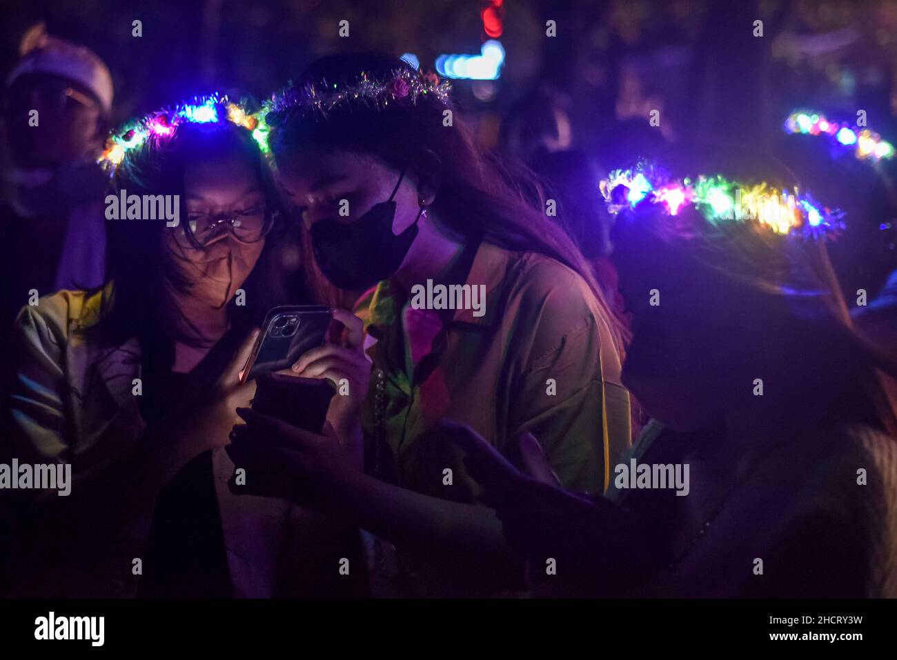 Bali, Indonesien. 31st Dez 2021. Frauen mit Gesichtsmasken und Kopfzubehör feiern das neue Jahr in Bali, Indonesien, 31. Dezember 2021. Quelle: Bisinglasi/Xinhua/Alamy Live News Stockfoto