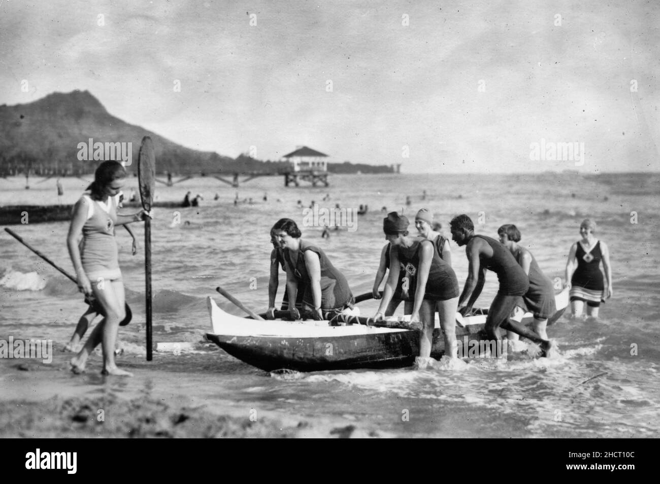 Frauen-Lebensretter schleppen in Waikiki ein Auslegerkanu hoch. Nach dem Training in der Brandung ziehen diese Mitglieder des lebensrettenden Frauenkorps ihr Boot unter der Leitung von David Kehanemoku, dem berühmten Kanumann, 1920, hoch Stockfoto