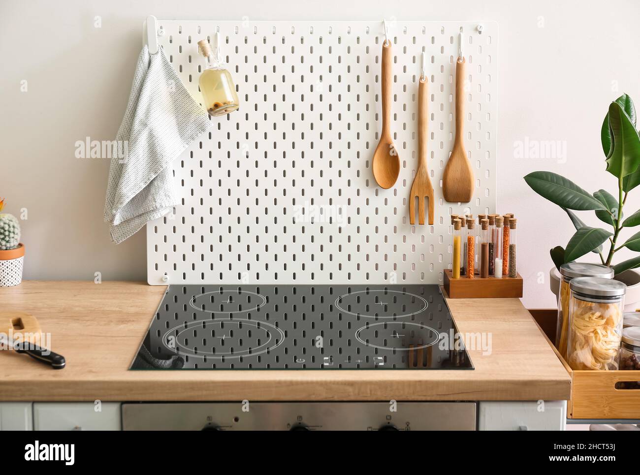 PEG-Tafel mit Serviette, Ölflasche und Spachtel auf Küchentische in der Nähe der Lichtwand Stockfoto