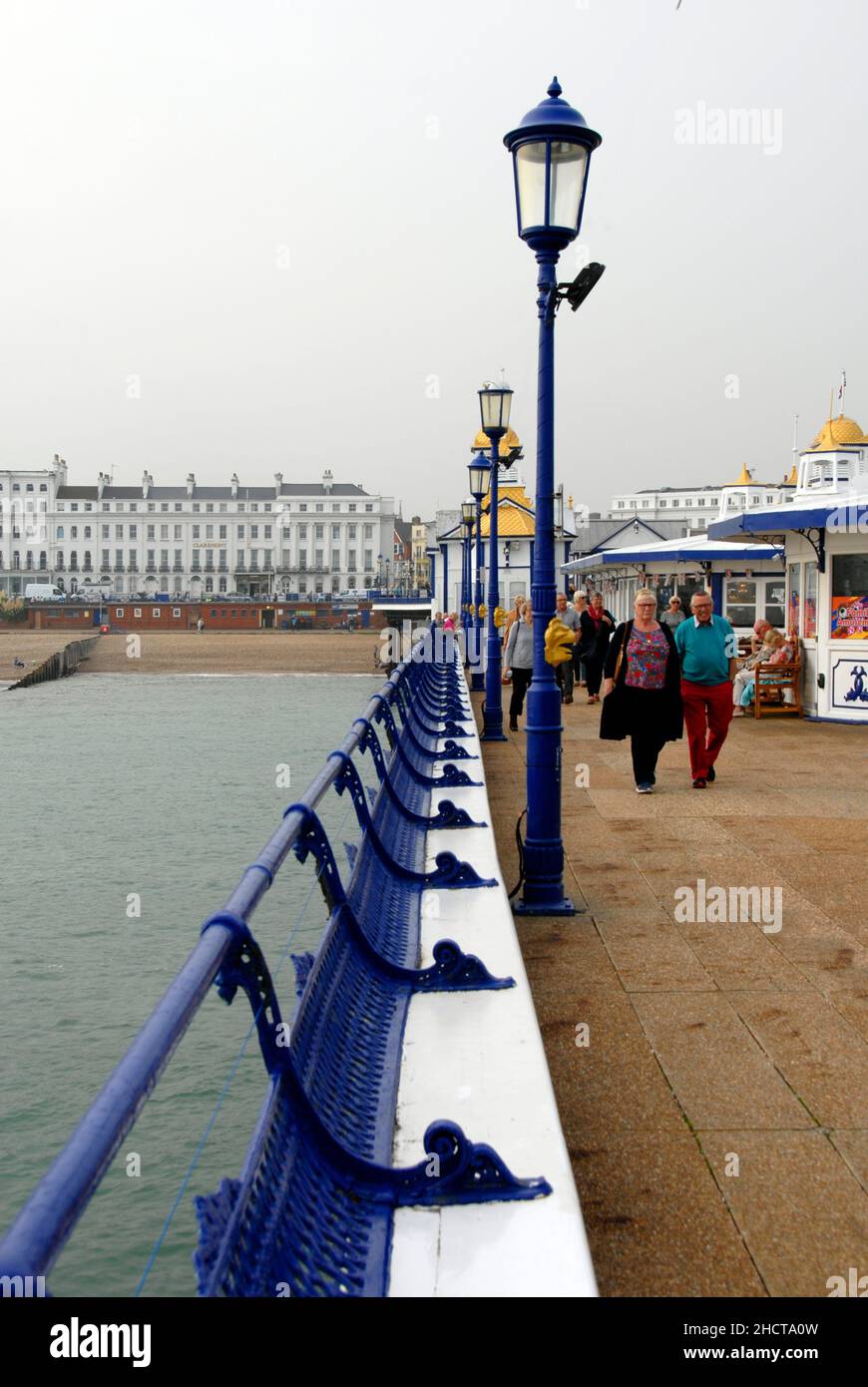 Menschen, die am Eastbourne Pier, East Sussex, England, spazieren Stockfoto