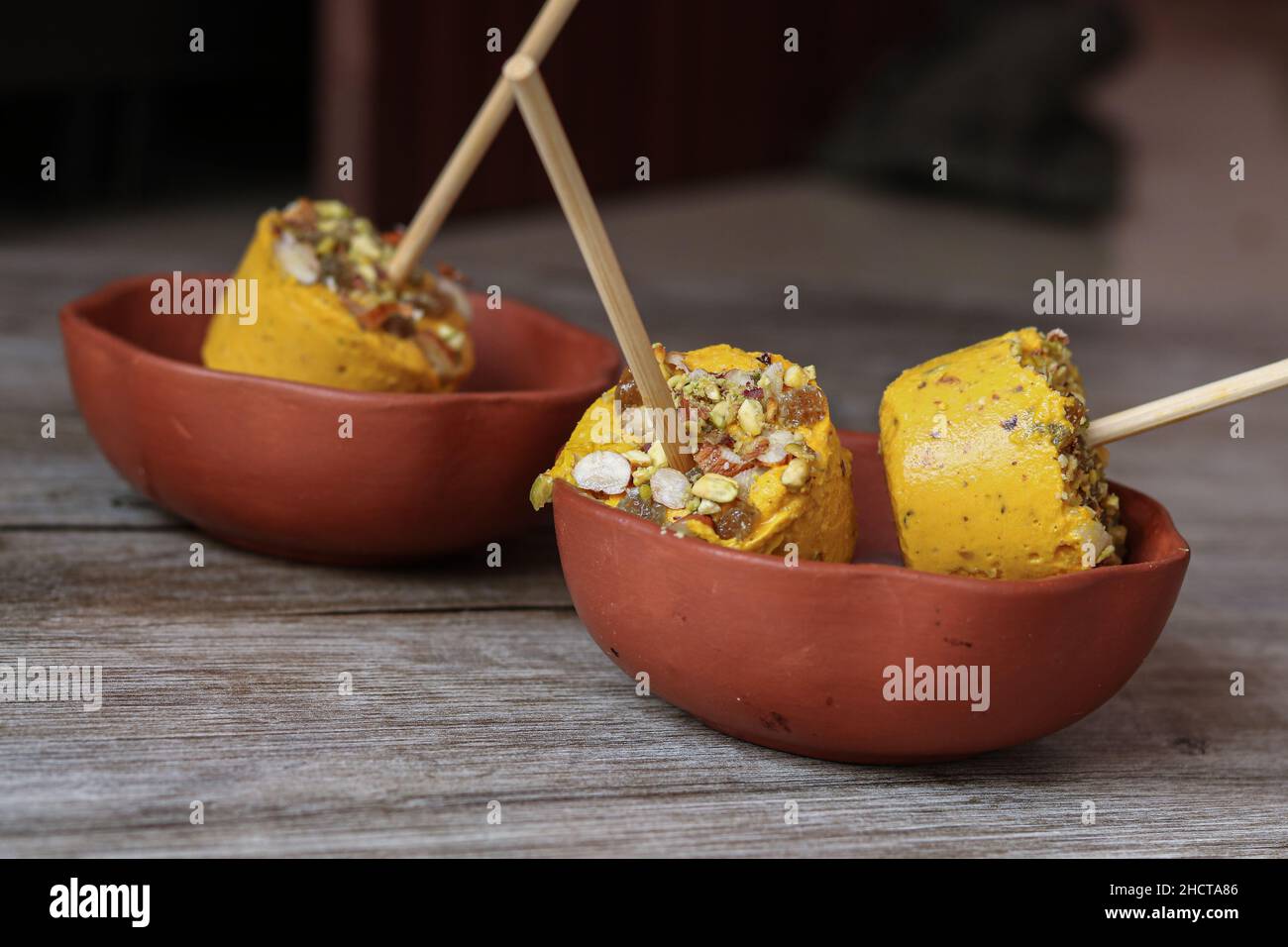 DAS BILD ENTHÄLT VEGANE MANGO KULFI MIT EXTRAKT AUS MANGO UND KOKOSNUSS. Stockfoto