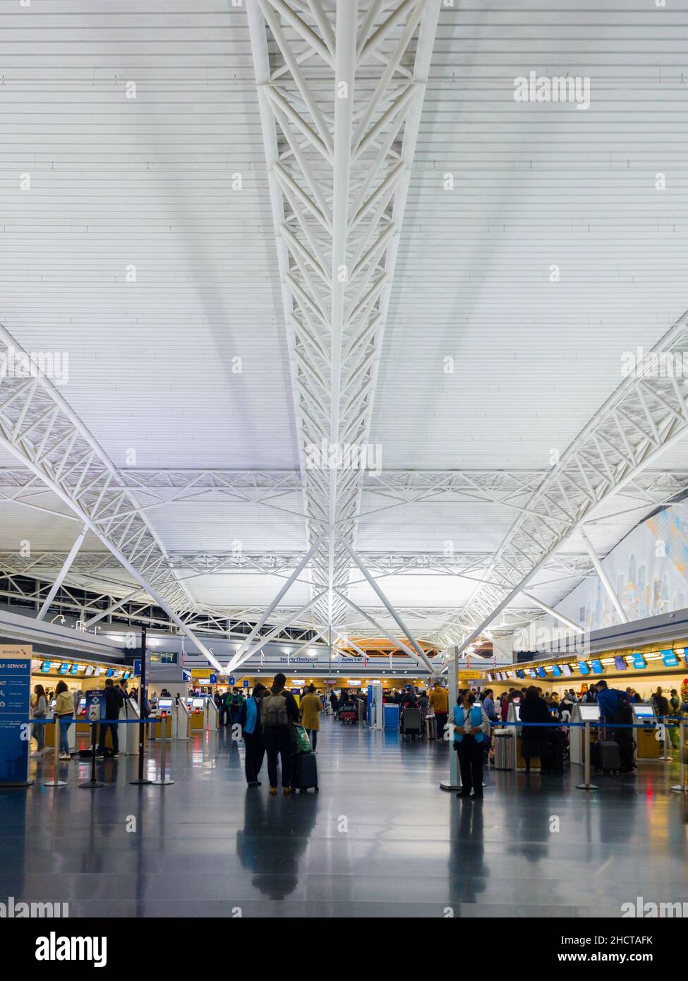 Jamaika, New York - 12. Dezember 2021: Vertikale Ansicht des Terminals 8 des JFK Airport mit Personen, die Gepäck einchecken. Stockfoto