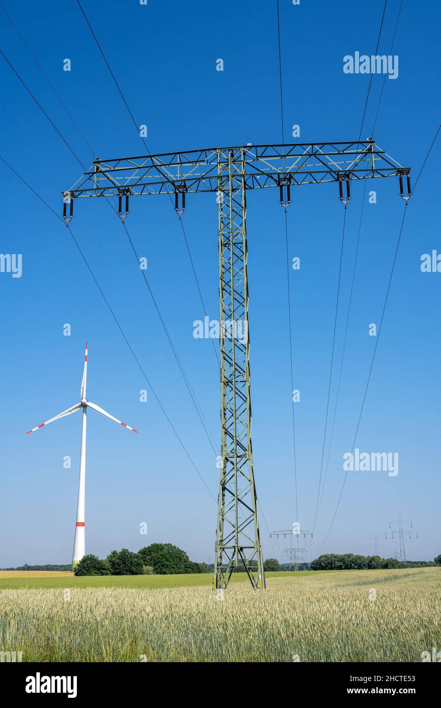 Strompylon, Freileitungen und eine Windturbine in Deutschland zu sehen Stockfoto