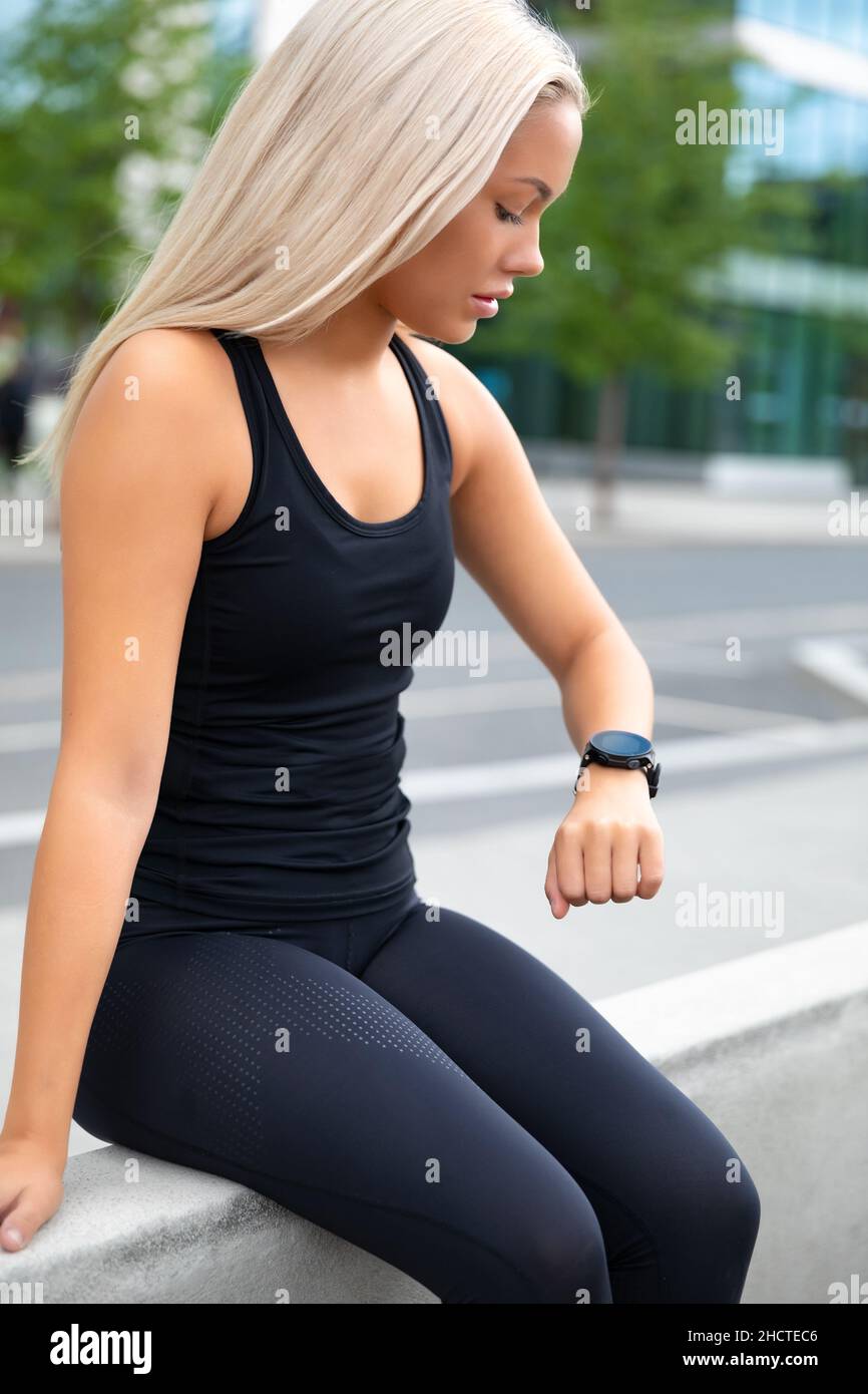 Ruhende Frau überprüft nach dem Training die Leistung und Verfolgung auf Smartwatch Stockfoto